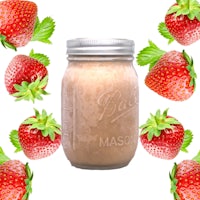 a mason jar surrounded by strawberries