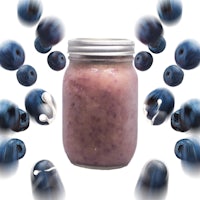 a jar of blueberry smoothie surrounded by blueberries